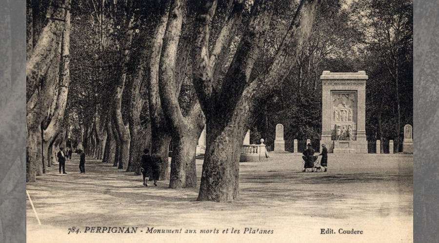 photo:à gauche allées de platanes ; a droite:le monument rectabgulaire entouré de ses 4 stèle avec mosaîque