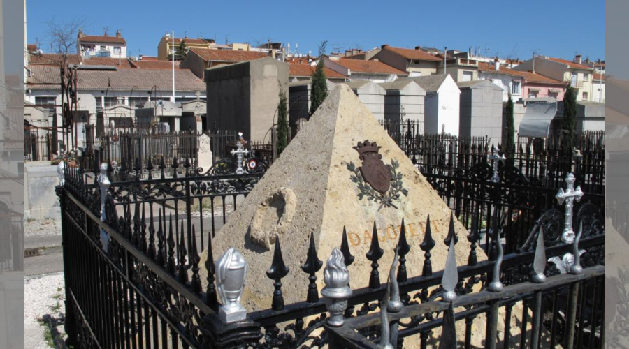 Tomeau en forme de pyramide entourée d'une grille, le blason de Dagobert:2 licornes et un lion séparé par un V pointe en haut.