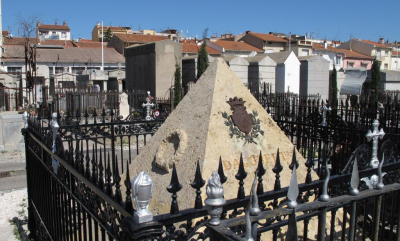 Tomeau en forme de pyramide entourée d'une grille, le blason de Dagobert:2 licornes et un lion séparé par un V pointe en haut.