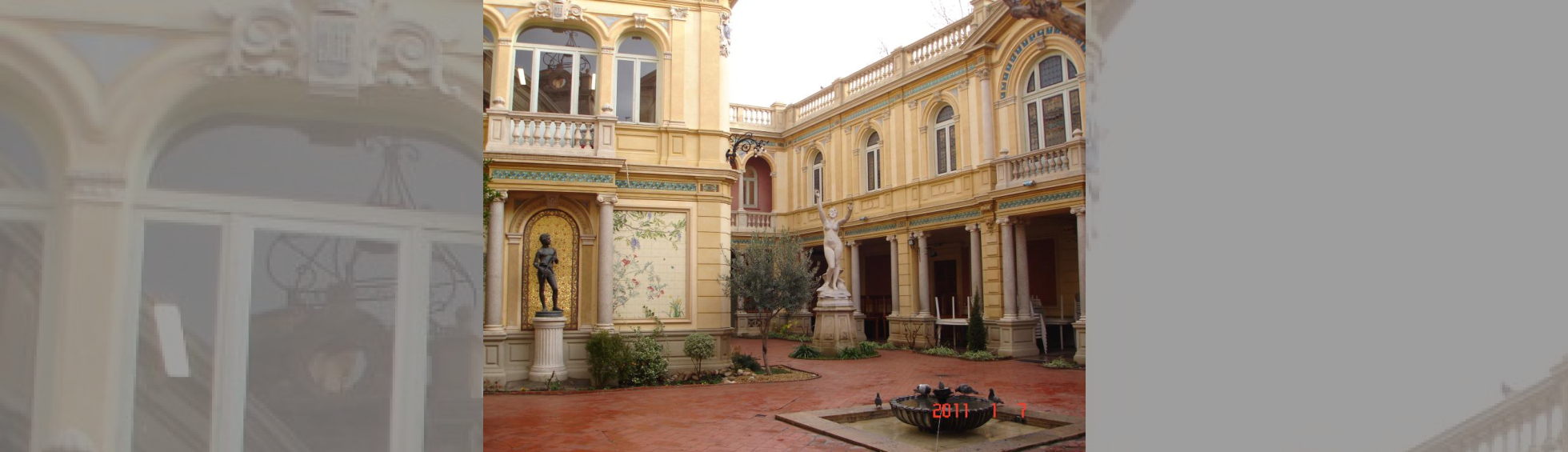 Hotel PAMS Patio:galerie couverte er arcades,décor floral, statue d'une femme nue dansant et d'un enfant avec une flute