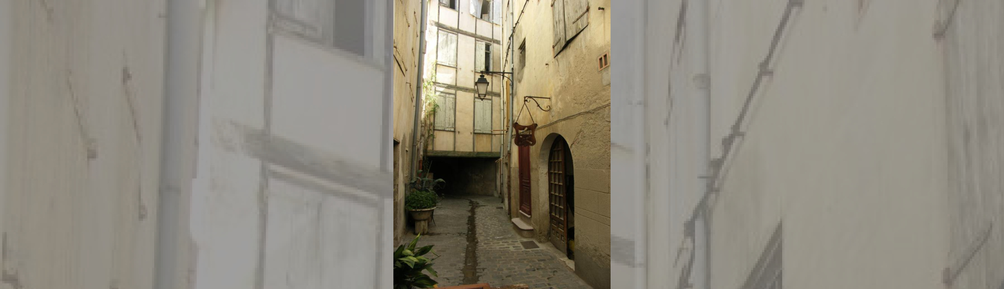 L'intérieur du coronell : des enseignes de fer au dessus d'une entrée d'atelier d'artisan.