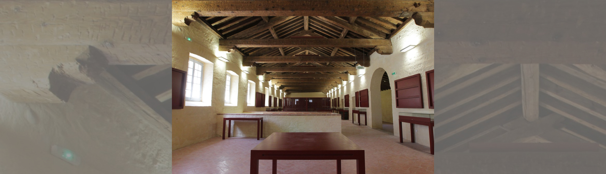 Ancien dortoir transformé en salle d'exposition: belle charpente en bois apparente, sol en terre cuite 